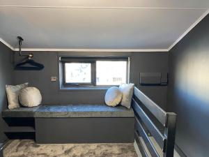 Habitación con banco con almohadas y ventana en Seascape - Floating Home at Brighton Marina with free Parking, en Brighton & Hove