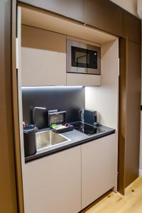 a kitchen with a sink and a microwave at Vittorio 73 Luxury Apartment in Turin