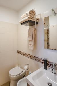 a white bathroom with a toilet and a sink at Vittorio 73 Luxury Apartment in Turin