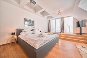 una camera con un grande letto e una TV a schermo piatto di Smile Apartments "Weinhimmel" a Krems an der Donau