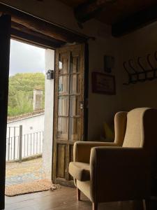 ein Zimmer mit 2 Stühlen und einer offenen Tür in der Unterkunft La Casa del Castaño in Castañuelo