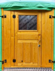 a wooden door with a window and a green roof at Jurte 