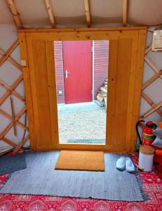 une porte donnant sur une pièce avec une porte rouge dans l'établissement Jurte, à Ernstbrunn 10 autres photos