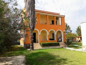 an orange house with a tree in front of it at Irini Apartments and Studios in Kavos