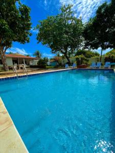 une grande piscine d'eau bleue dans l'établissement Casa Ana Frank, à Parajuru