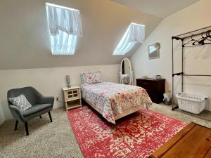 1 dormitorio con cama, silla y espejo en Leah's Homestay in Hoquiam en Hoquiam