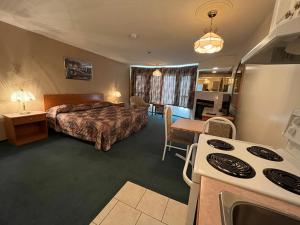 a hotel room with a bed and a kitchen at Western Budget Motel #3 Whitecourt in Whitecourt