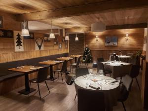 a restaurant with tables and chairs and a christmas tree at Hotel Valle Pesio Ristorante in Chiusa di Pesio