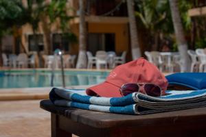 einen Hut und eine Sonnenbrille auf einem Tisch in der Nähe eines Pools in der Unterkunft Tecnohotel Beach in San Benito