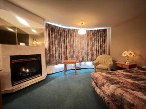Habitación de hotel con chimenea y cama en Western Budget Motel #3 Whitecourt en Whitecourt