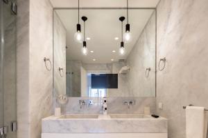 a bathroom with two sinks and a large mirror at Chiado Mercy Apartments | Lisbon Best Apartments in Lisbon