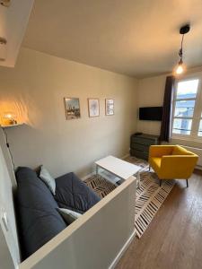 a living room with a couch and a yellow chair at Appart du Théâtre in Caen