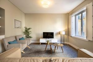 a living room with a couch and a tv at Chiado Mercy Apartments | Lisbon Best Apartments in Lisbon