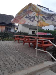 two picnic tables with an umbrella on a patio at Restaurace Hamburk s ubytováním in Beroun