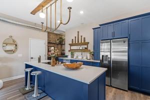 a kitchen with blue cabinets and a stainless steel refrigerator at King Sweet, 2bd, 1 bath, in Historic Walker's Point in Milwaukee