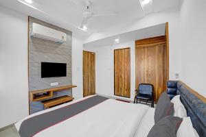 una camera con letto, TV e sedia di HOTEL TAPOVAN IN a Ahmedabad