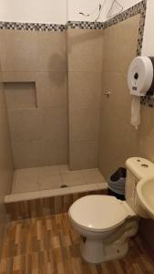 ein Badezimmer mit einem weißen WC und einer Dusche in der Unterkunft EDIFICIO CUPIL in Puerto Baquerizo Moreno
