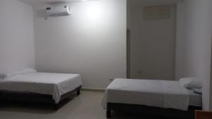 1 Schlafzimmer mit 2 Betten und einer Wand in der Unterkunft EDIFICIO CUPIL in Puerto Baquerizo Moreno