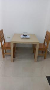 einem Holztisch mit zwei Stühlen und einem Tisch mit einer Platte darauf in der Unterkunft EDIFICIO CUPIL in Puerto Baquerizo Moreno