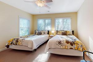 2 bedden in een slaapkamer met ramen en een plafondventilator bij Bayside Resort - 36516 Coneflower Cir in Selbyville