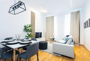 un salon blanc avec une table et un canapé dans l'établissement OrestaLiving - Spacious 2BR on the Danube Canal, à Vienne