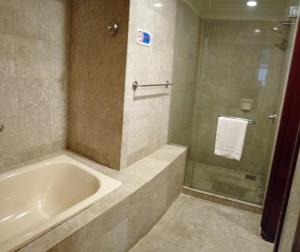 a bathroom with a tub and a glass shower at Crown Apartment at Times Square in Kuala Lumpur