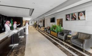 a hotel lobby with a bride and groom walking down the hallway at Ewan Dar Alhejra Hotel in Al Madinah