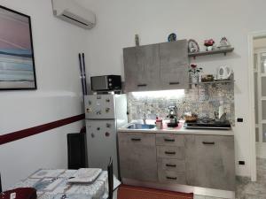 eine kleine Küche mit Kühlschrank und Spüle in der Unterkunft GevyNapule in Neapel