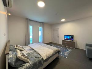 a bedroom with a bed and a flat screen tv at Labella Chalet in Barka