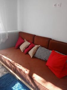 ein braunes Sofa mit vier Kissen darauf in der Unterkunft Σαν Παραμυθάκι in Filýra