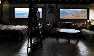 sala de estar con sofá y mesa en Apartamento Rural El Herrero vistas espectaculares a Gredos en Cabezas Bajas