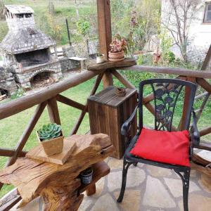 Ein Stuhl und ein Tisch auf einer Veranda mit Kamin in der Unterkunft Σαν Παραμυθάκι in Filýra + 25 Fotos