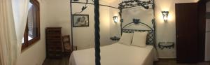 - une chambre avec un lit à baldaquin noir et blanc dans l'établissement Lugar das Andorinhas, à Albufeira