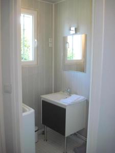 ein Badezimmer mit einem Waschbecken, einer Badewanne und einem Spiegel in der Unterkunft Le Clos D'aval Le Paulownia in Saint-Nicolas-dʼAliermont