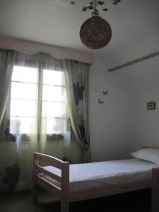 ein kleines Schlafzimmer mit einem Bett und einem Fenster in der Unterkunft Le Clos D'aval Le Paulownia in Saint-Nicolas-dʼAliermont