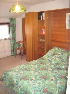 ein Schlafzimmer mit einem Bett und einem Bücherregal in der Unterkunft Le Clos D'aval Le Paulownia in Saint-Nicolas-dʼAliermont