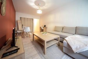 a living room with a couch and a table at L'escale mauricienne in Chalon-sur-Saône