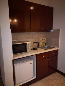 a small kitchen with a microwave and a sink at Crown Apartment at Times Square in Kuala Lumpur