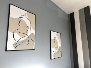 twee kunstwerken aan een muur bij Luxury Suite in Colchester Town Centre By Station in Colchester