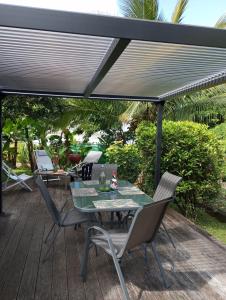 a patio with a table and chairs under awning at Les poinsettias in Les Trois-Îlets