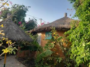 uma pequena casa com telhado de palha em Campement Baobab em Poponguine