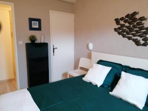 een slaapkamer met een groen en wit bed met 2 kussens bij La plume du Ventoux in Mollans-sur-Ouvèze