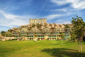 un gran edificio en lo alto de un exuberante campo verde en Gold City 5 star resort 2+1 appartement sea view and aqua park, en Alanya