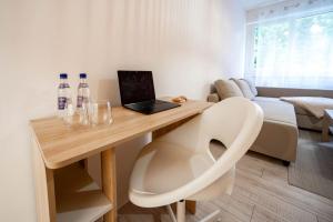 Zimmer mit einem Schreibtisch, einem Laptop und einem Stuhl in der Unterkunft Le studio tropical in Chalon-sur-Saône