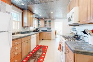 a kitchen with wooden cabinets and a red rug on the floor at Town of Rehoboth Beach 45 Baltimore Ave in Rehoboth Beach