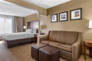 a hotel room with a bed and a couch at Comfort Suites Grandville - Grand Rapids SW in Grandville +19 photos