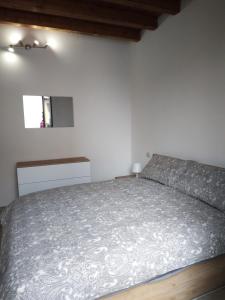 een slaapkamer met een bed met een grijze sprei bij Rho appartamento in centro in Rho
