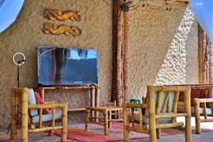 a room with chairs and a tv and a mirror at IGUANA HOUSE in Máncora