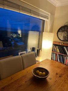 Beautiful 2 bedroom beach getaway في بيفينسي: وعاء من الفواكه على طاولة خشبية في غرفة المعيشة