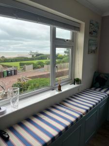 asiento junto a la ventana en una habitación con vistas en Beautiful 2 bedroom beach getaway, en Pevensey